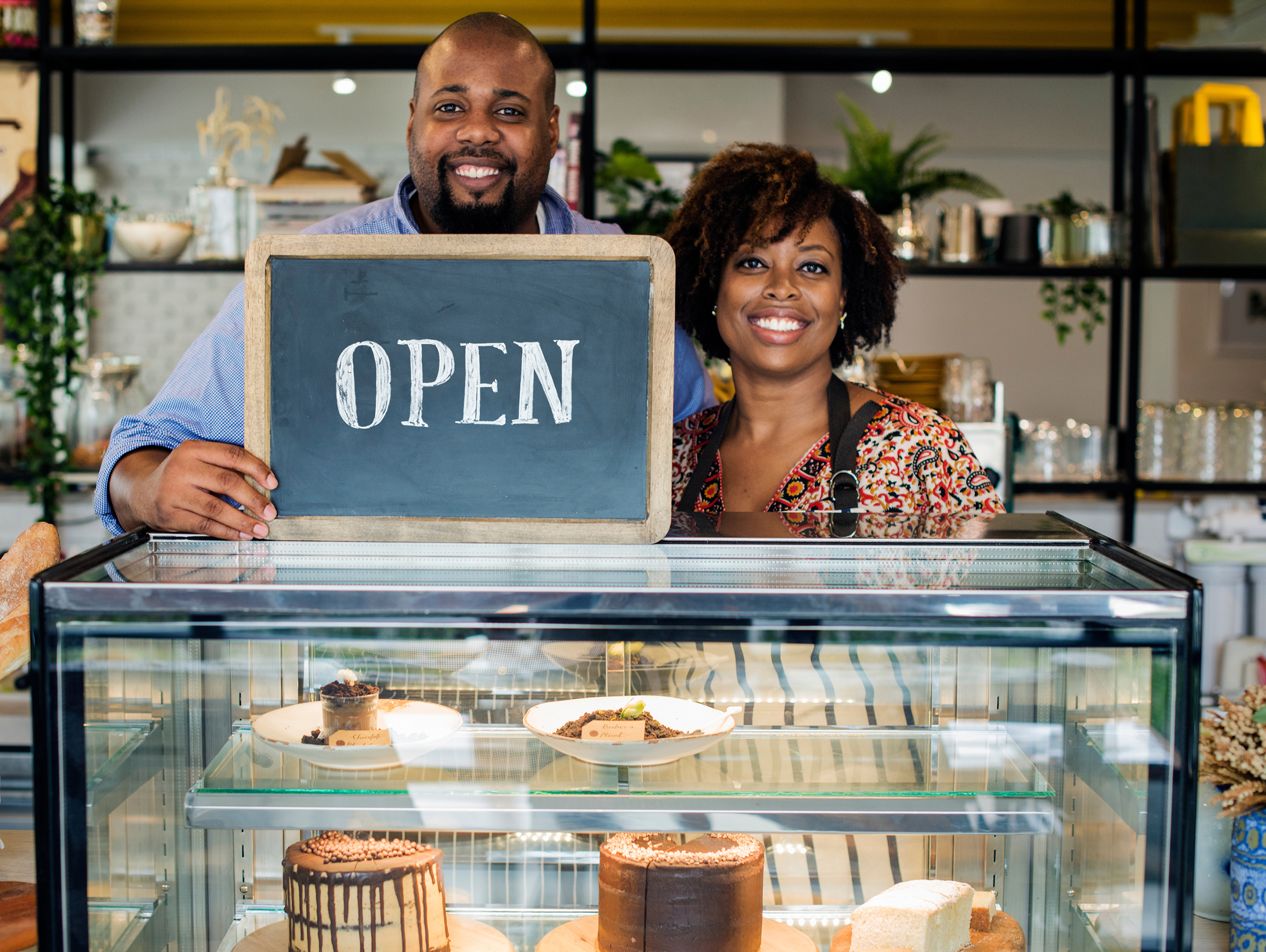 Shop owners with open sign