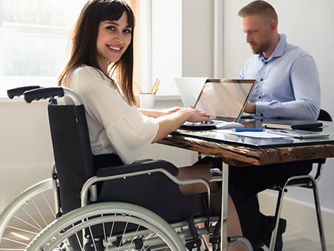 Woman in a wheelchair working alongside a male co-worker