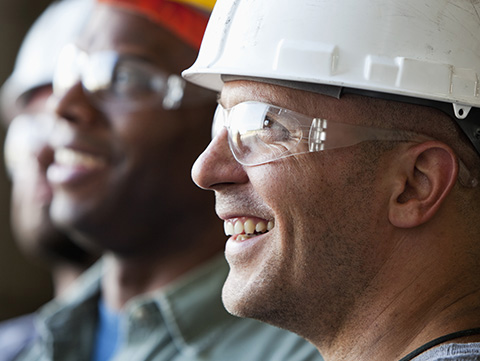 Group of men in construction hats and safety glasses